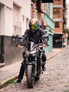 Person in Biker Gear and Helmet Sitting on Kawasaki Motorcycle